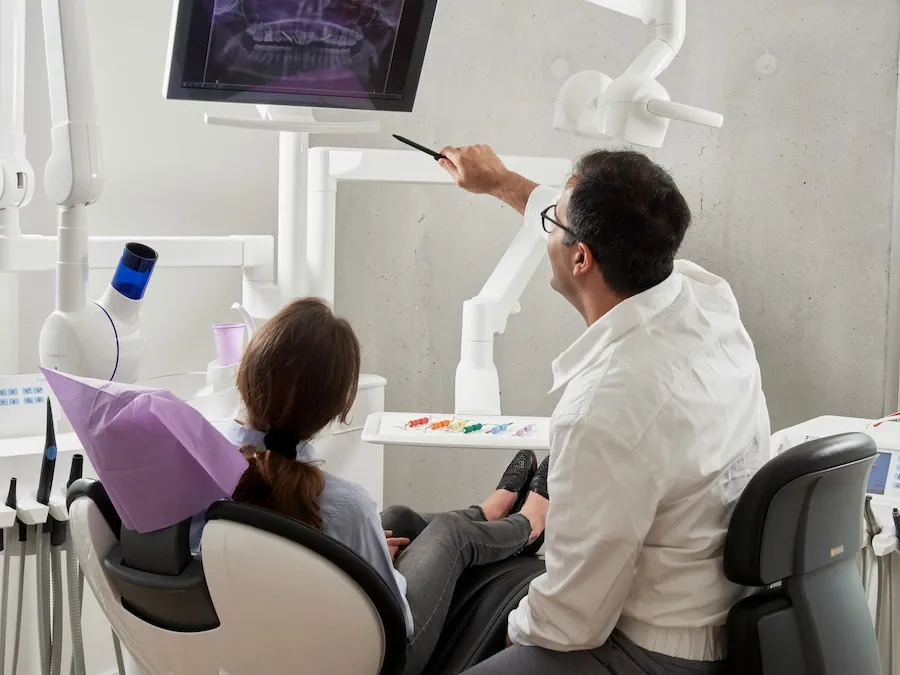 Dentist reviewing digital X-rays with an international patient during a treatment consultation in Istanbul.
