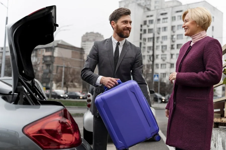 Private driver assisting an international patient with luggage before transportation to a dental clinic in Istanbul.